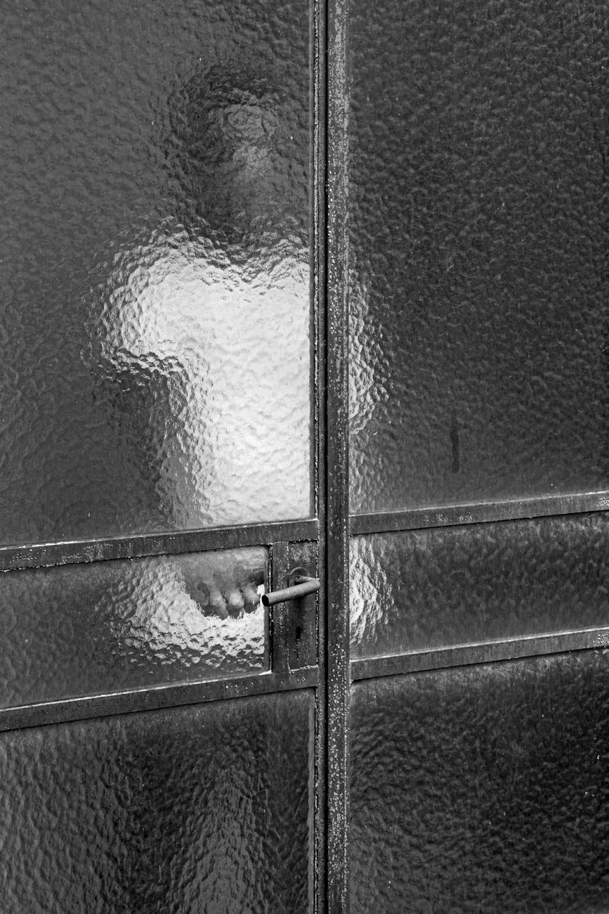 Mysterious silhouette of a person standing behind a textured glass door in Buenos Aires.