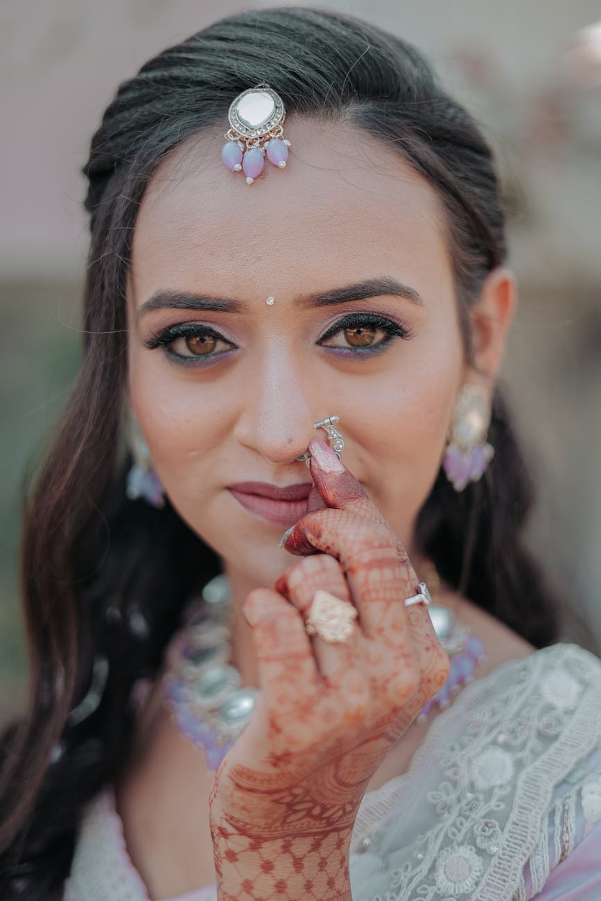 Close-up of an Indian bride showcasing intricate henna and elegant jewelry.